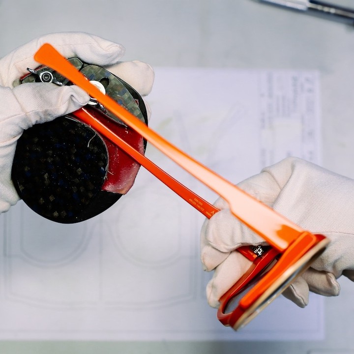 Étape de fabrication à la main : création du cambre, la courbure d'une branche orange